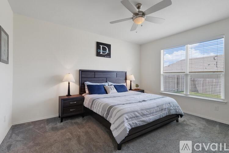 A bedroom with a large bed and a ceiling fan.