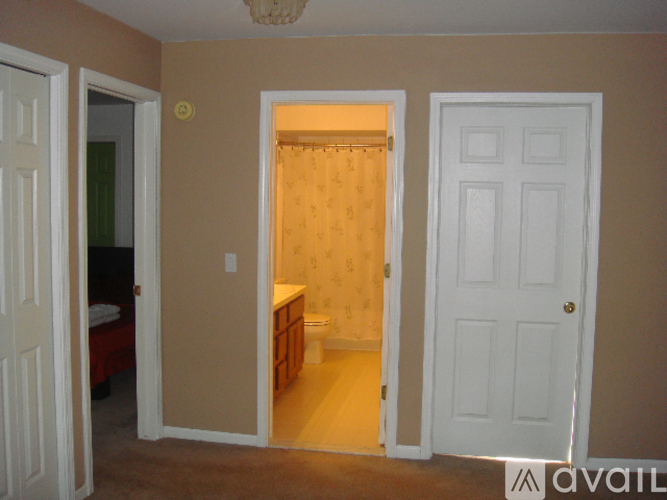 A bedroom with a toilet and a bed in the corner.