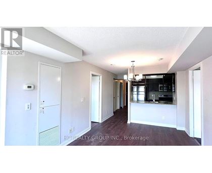 A spacious kitchen and dining area with white walls and a wooden floor.
