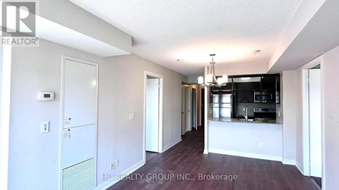 A spacious kitchen and dining area with white walls and a wooden floor.
