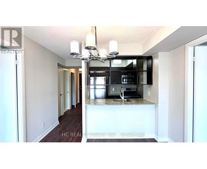 A kitchen with a granite countertop and a fridge.