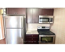 A kitchen with a stainless steel refrigerator, microwave, and oven.