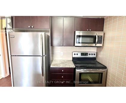 A kitchen with a stainless steel refrigerator, microwave, and oven.