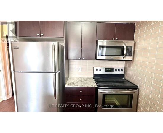 A kitchen with a stainless steel refrigerator, microwave, and oven.