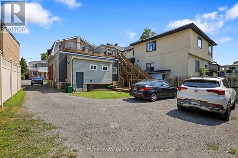 A gravel driveway leads to a two-story house with a garage.