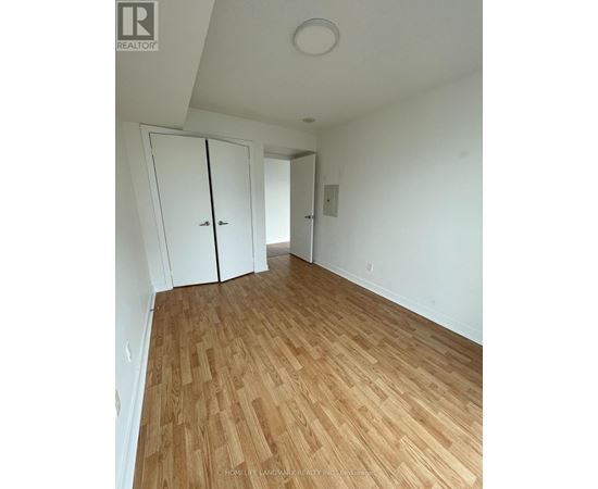 A room with wooden flooring and white walls.