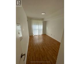 A room with wooden flooring and white walls.