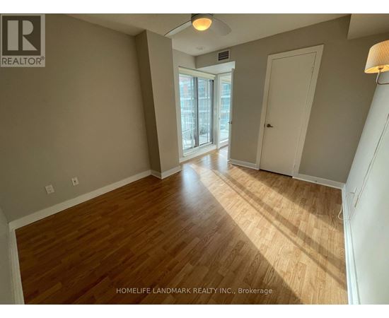 A room with wooden flooring and a sliding glass door.