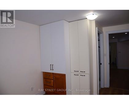 A white cabinet with a drawer is in the middle of a room.