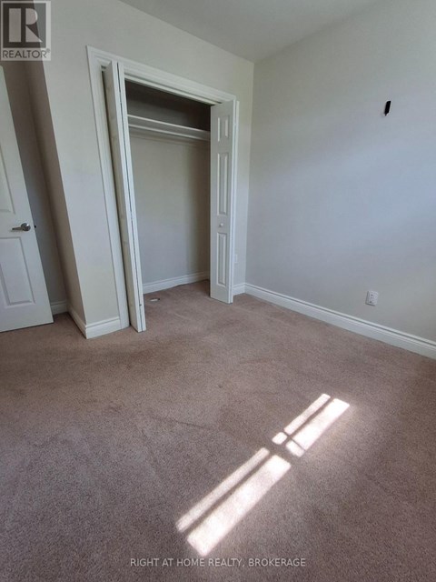 A room with a carpeted floor and a doorway leading to another room.
