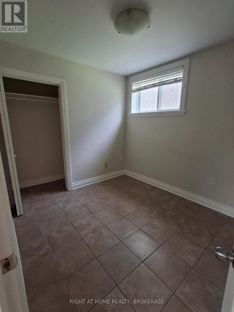 A room with tile flooring and a window.
