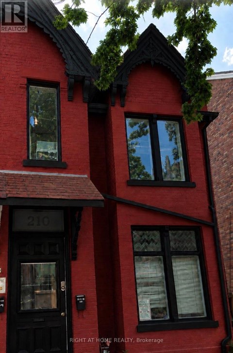 A red brick house with a black door and windows.