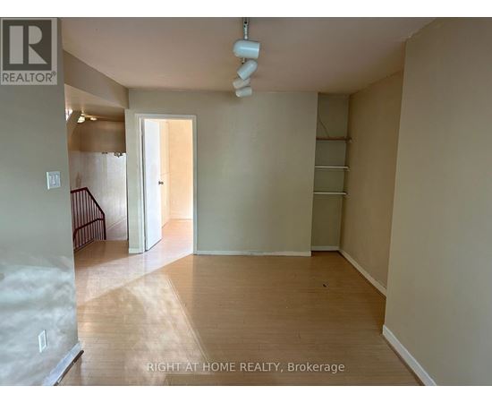 A room with a wooden floor and a white ceiling with a light fixture.