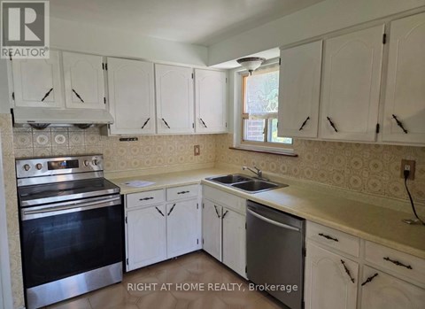 A kitchen with white cabinets and a stainless steel oven.