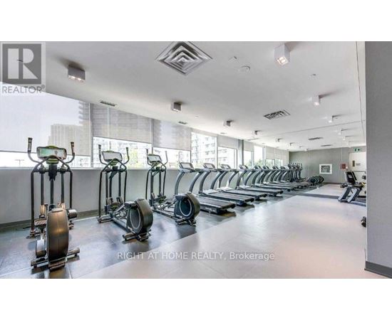 A gym with a row of exercise bikes and a sign that says "Right at Home Realty, Brokerage".