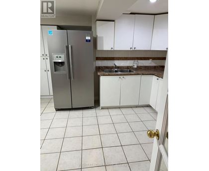 A kitchen with a stainless steel refrigerator and white cabinets.