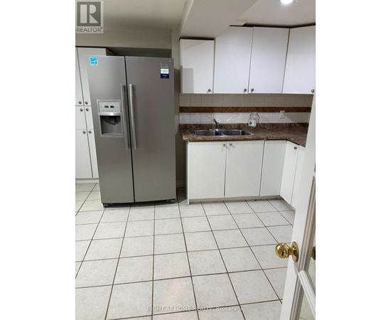 A kitchen with a stainless steel refrigerator and white cabinets.