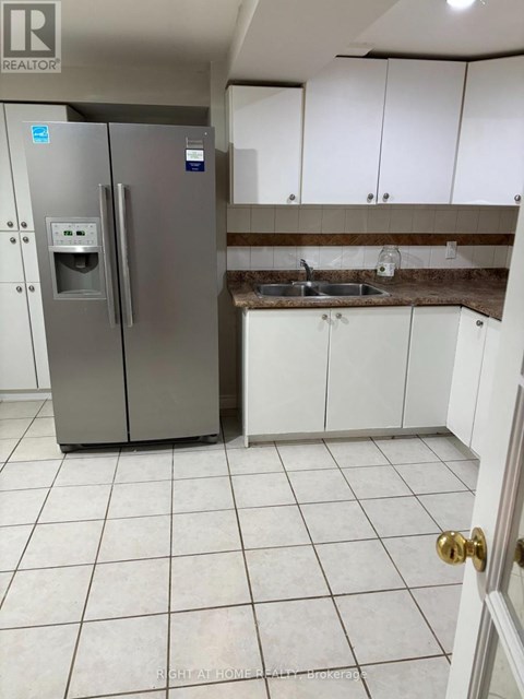 A kitchen with a stainless steel refrigerator and white cabinets.