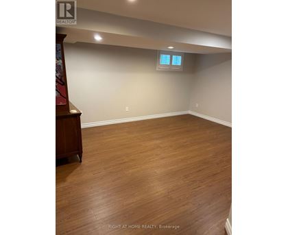 A room with wooden flooring and a window with blinds.
