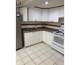 A kitchen with white cabinets and a stove top oven.