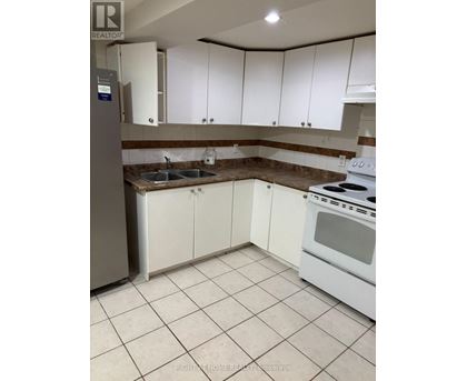 A kitchen with white cabinets and a stove top oven.