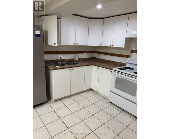 A kitchen with white cabinets and a stove top oven.