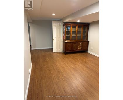 A room with wooden flooring and a cabinet with glass doors.