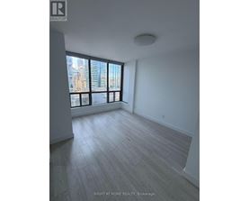 A spacious room with a large window overlooking a cityscape.