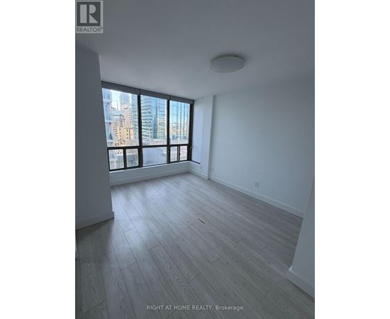A spacious room with a large window overlooking a cityscape.