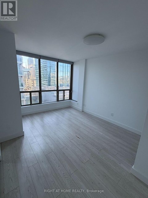 A spacious room with a large window overlooking a cityscape.
