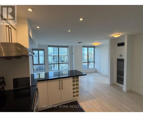A kitchen with a black counter top and white cabinets.
