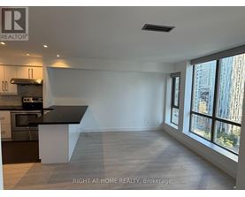 A spacious kitchen with a black countertop and stainless steel appliances.