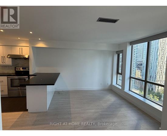 A spacious kitchen with a black countertop and stainless steel appliances.