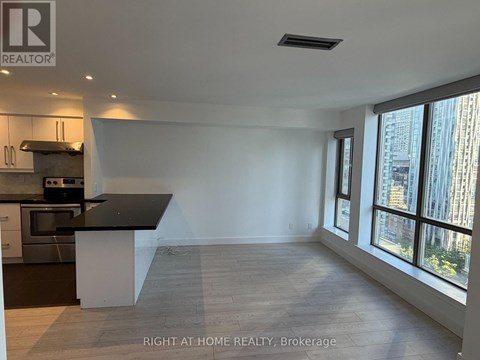 A spacious kitchen with a black countertop and stainless steel appliances.