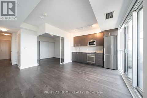 A spacious kitchen with a refrigerator, microwave, and oven.