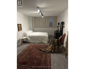 A bedroom with a white bed and a red rug.