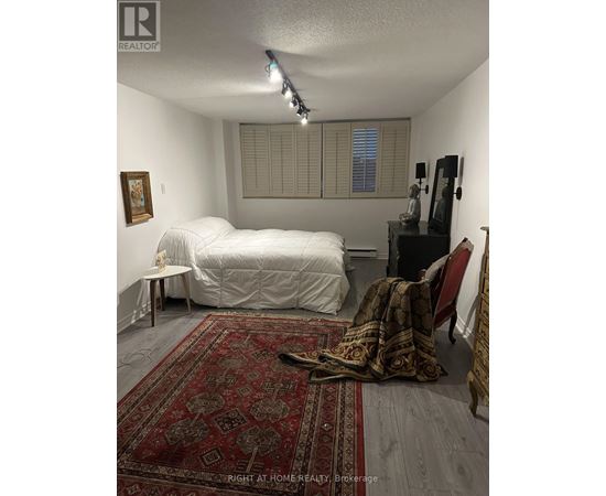 A bedroom with a white bed and a red rug.