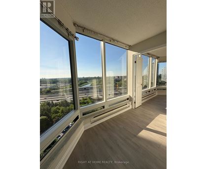A room with large windows overlooking a cityscape.