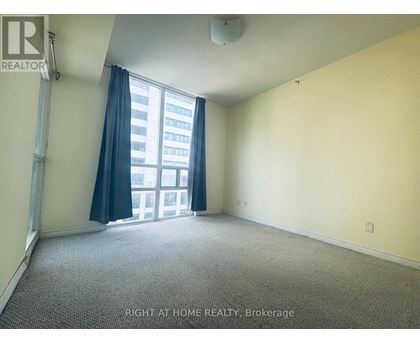 A room with a window and a carpeted floor.