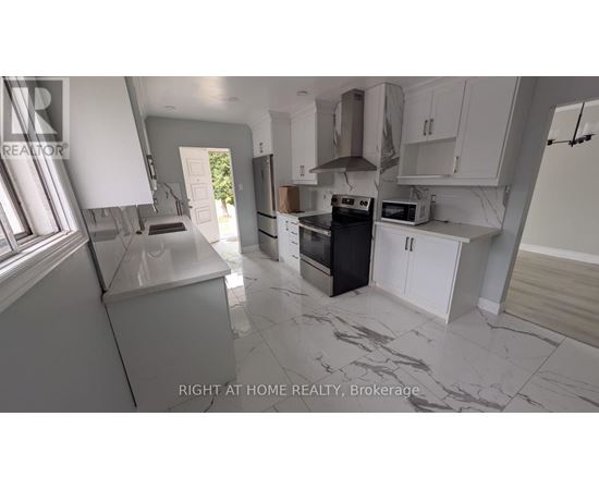 A kitchen with a black oven and white cabinets.