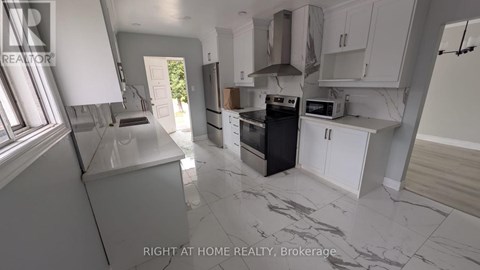 A kitchen with a black oven and white cabinets.