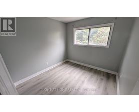 A room with a window and wooden flooring.