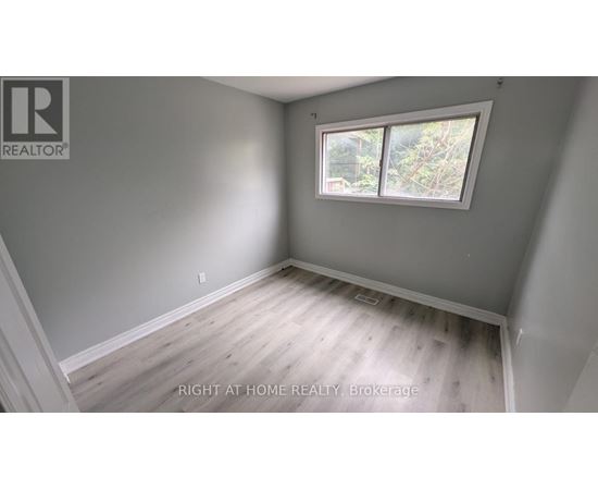 A room with a window and wooden flooring.