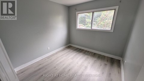A room with a window and wooden flooring.