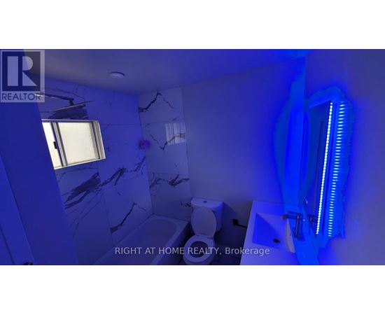 A bathroom with a blue light and a window.