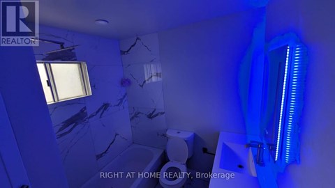 A bathroom with a blue light and a window.