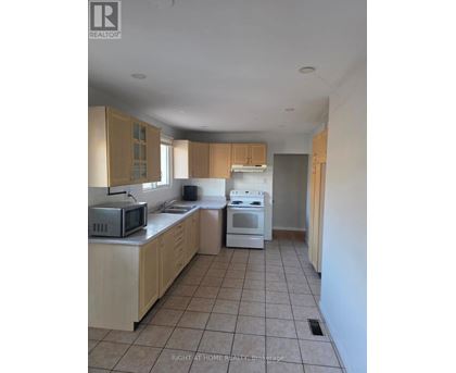 A kitchen with a microwave, oven, and cabinets.