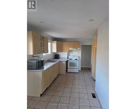 A kitchen with a microwave, oven, and cabinets.