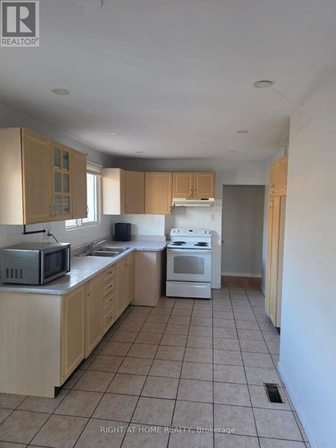 A kitchen with a microwave, oven, and cabinets.