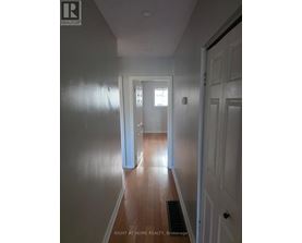 A hallway with a door on the right and a window on the left.